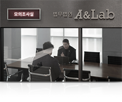 유리벽 회의실에서 마주 앉은 두 사람